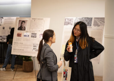 Two Celebration of Design attendees talking in front of boards highlighting Hideo Sasaki's history