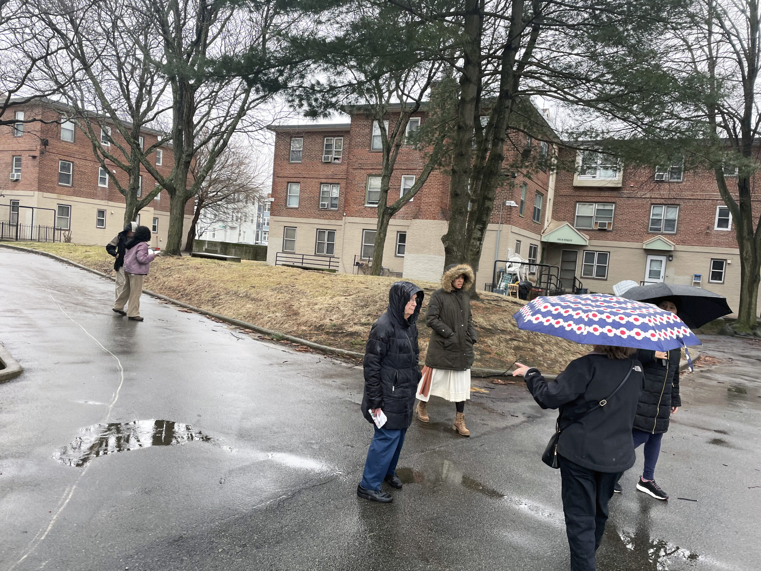 Several individuals in a housing complex's outdoor space